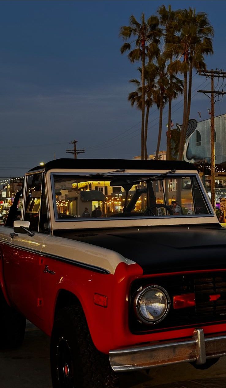 1975 Ford Bronco front three-quarter view at dusk in Venice